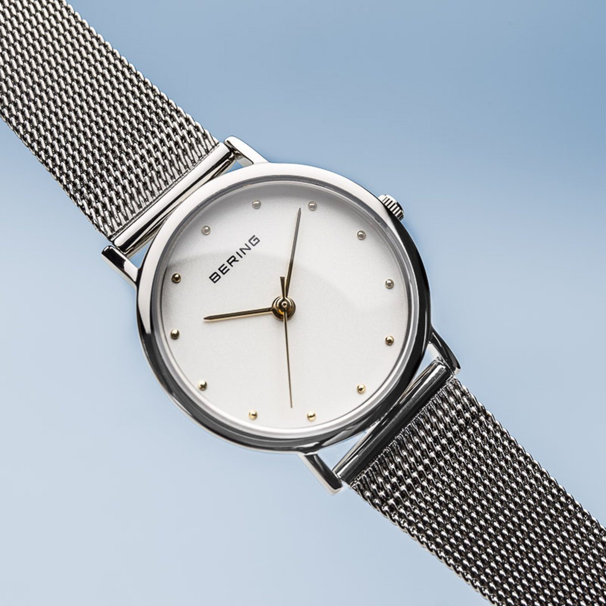 Reloj clásico de mujer con malla plateada y detalles dorados