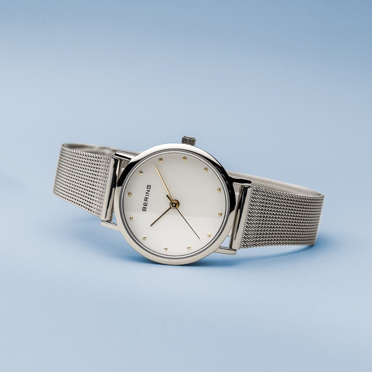 Reloj clásico de mujer con malla plateada y detalles dorados